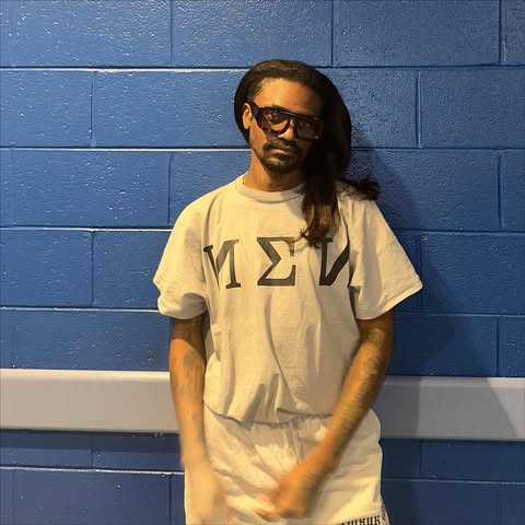 May be an image of sweatsuit, sweatpants and brick wall