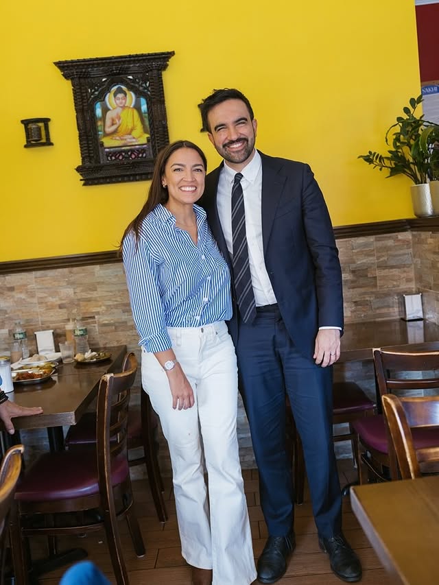 May be an image of smiling, blazer, suit and text