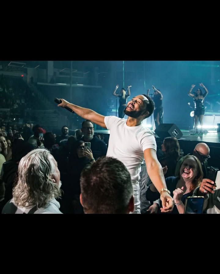 May be an image of one or more people, microphone, crowd, concert and text