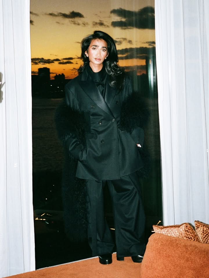 May be an image of one or more people, makeup, sable coat, overcoat, turtleneck and text