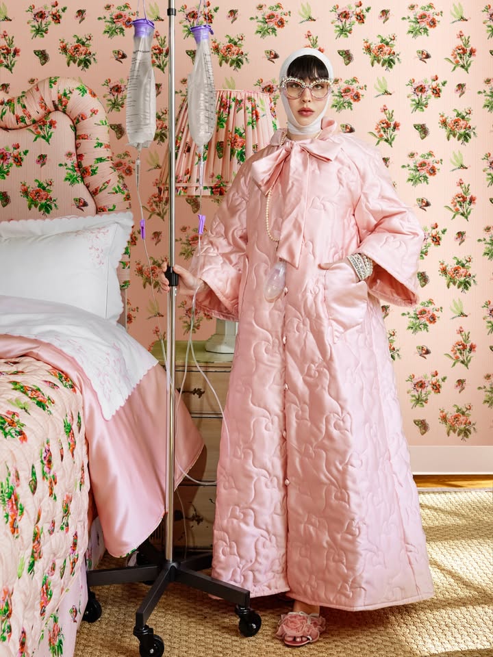 May be an image of sleepwear, overcoat, bed, bath robe, robe and text