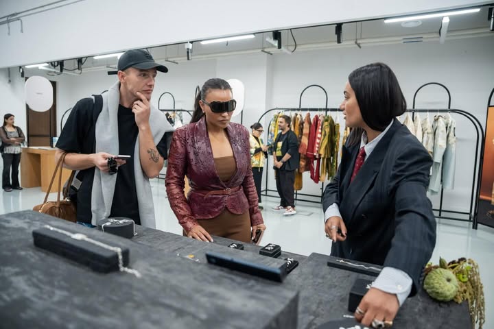 May be an image of one or more people, suit, overcoat, eyewear, neckwear and text