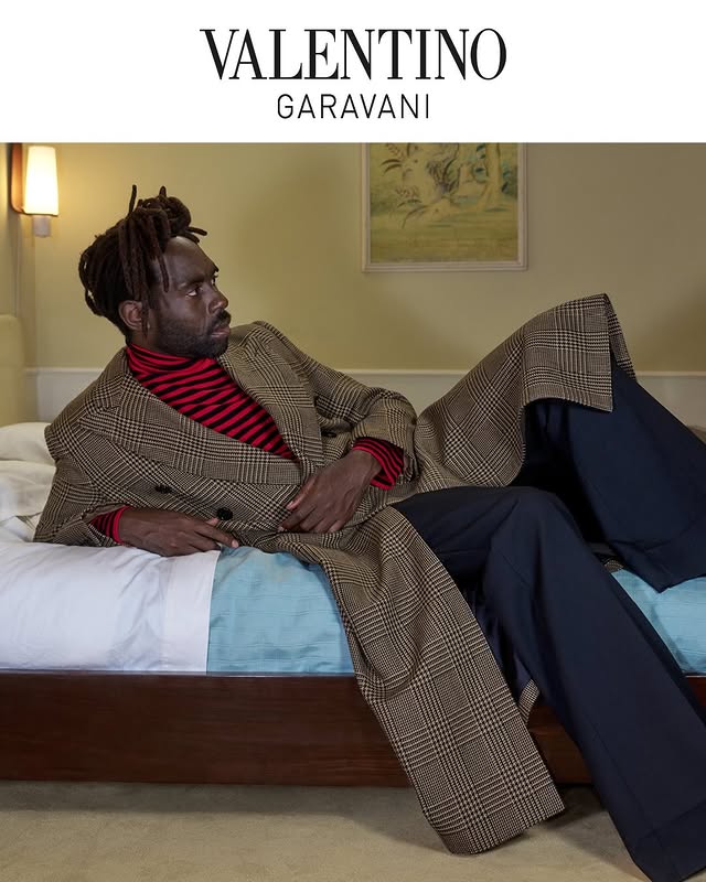 May be an image of overcoat, suit, magazine, neckwear and text