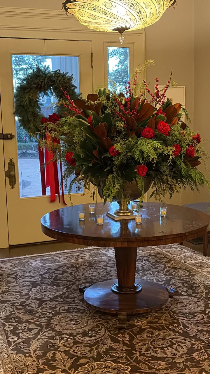 May be an image of flower arrangement, urn and text