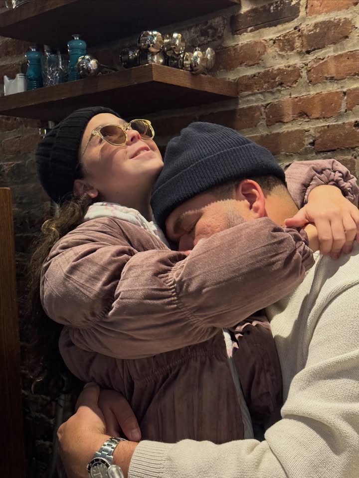 May be an image of people kissing, brick wall and text