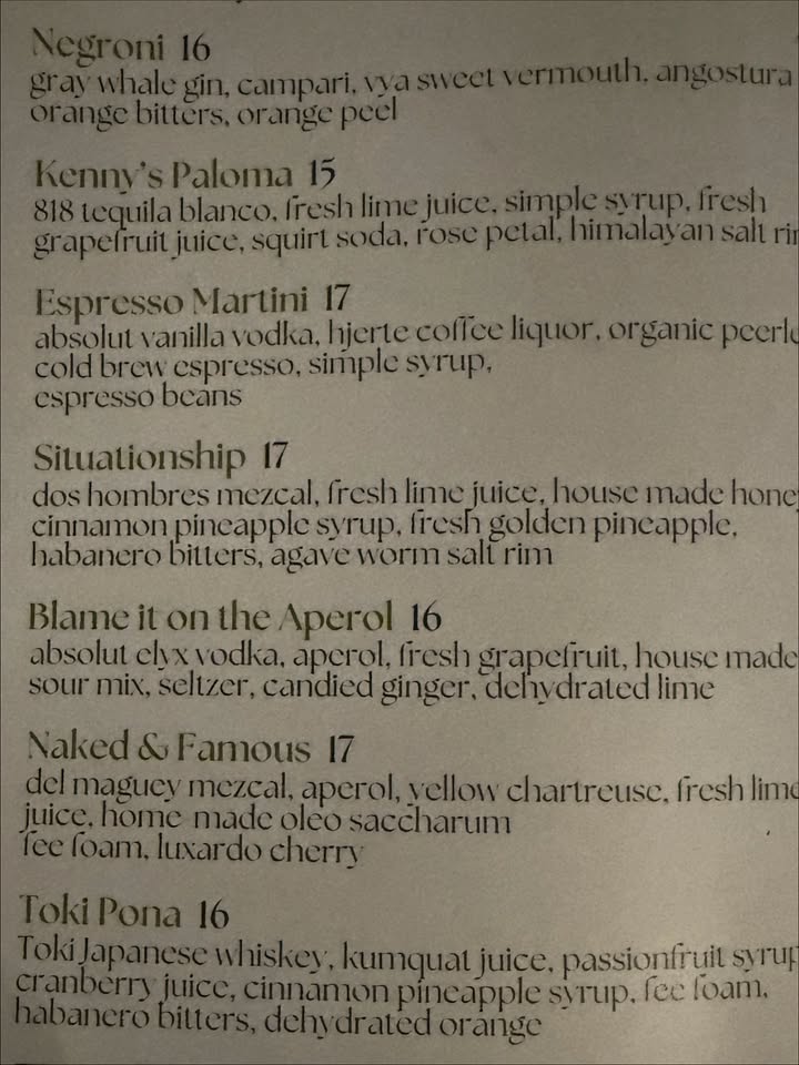May be an image of text that says 'Kenny's enny'sPaloma Paloma 15 tequila blanco. fresh limejuic grapefruitjuice, squirl soda, rose Espresso esso Martini 17 absolut vanilla vodka, hierte hjertecoficc hjertecoficeliquor.organicpeer peerl cold brew espresso, simple svrup, espresso beans Siluationship 17 doshombres mezcal, fresh lime juice. house made hone cinnamon oincapple syrup, fresh golden pincapple, habanero bitters, agavewe worm Blameit on the Aperol 16 absolut elv vodka. apcrol, fresh grapefiuit, house made sour mix, selizer, candied ginger, dehydrated lime Naked& 17 delmagucymczcal, vmezcal, aperol, yellow chartreusc. fresh lime juice. homemadeoleo oleo saccharum fecloam.luxardocherr TokiPona16 kumquat juice, passionfruit syrup cinnamonpincapples sytup. fee foam. dehydratedorange'