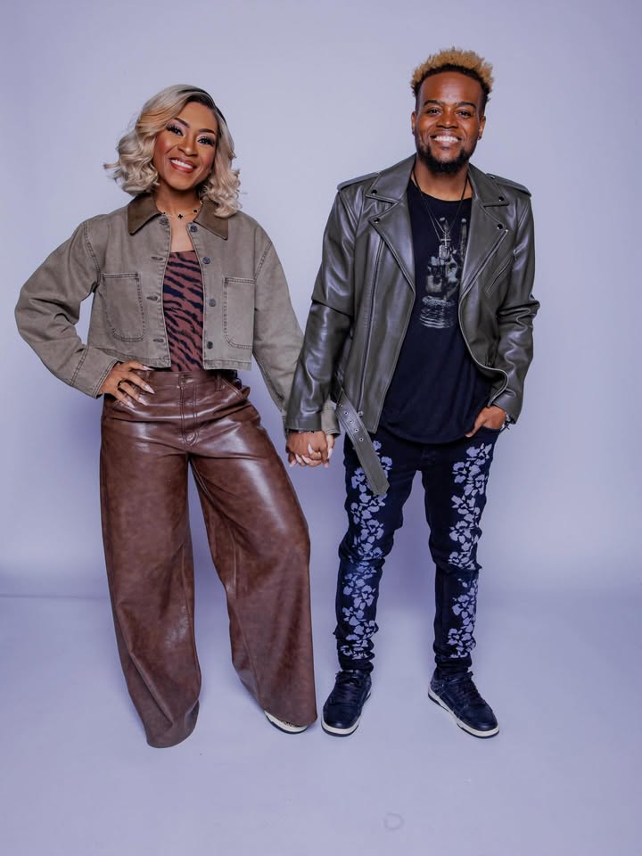 May be an image of one or more people, people smiling, people standing, jacket and text