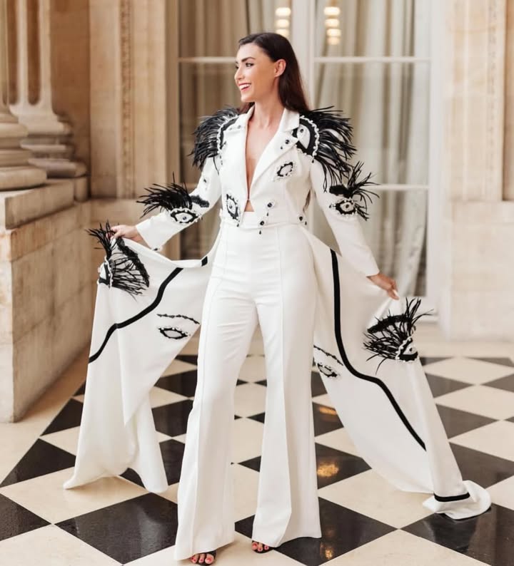 May be an image of overcoat, jumpsuit, suit, blazer and text