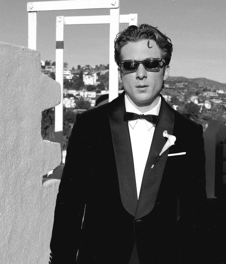 May be a black-and-white image of one or more people, suit, dinner jacket and text