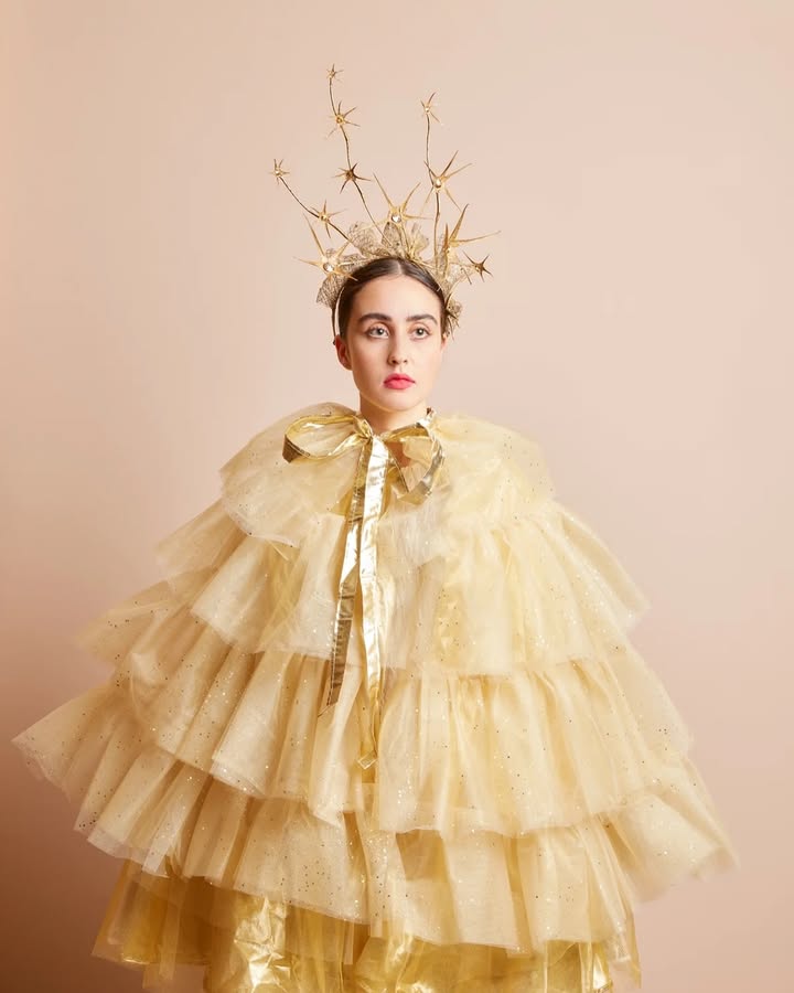 May be an image of one or more people, makeup, headdress, dress and text