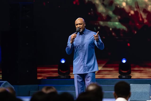 May be an image of one or more people, microphone and text