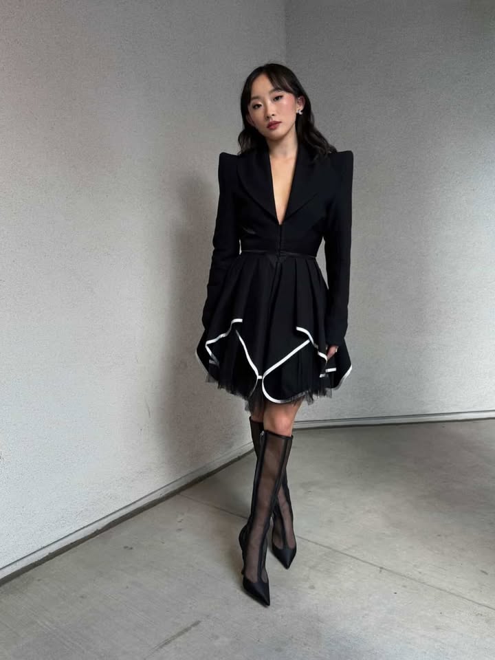 May be an image of overcoat, dress and text