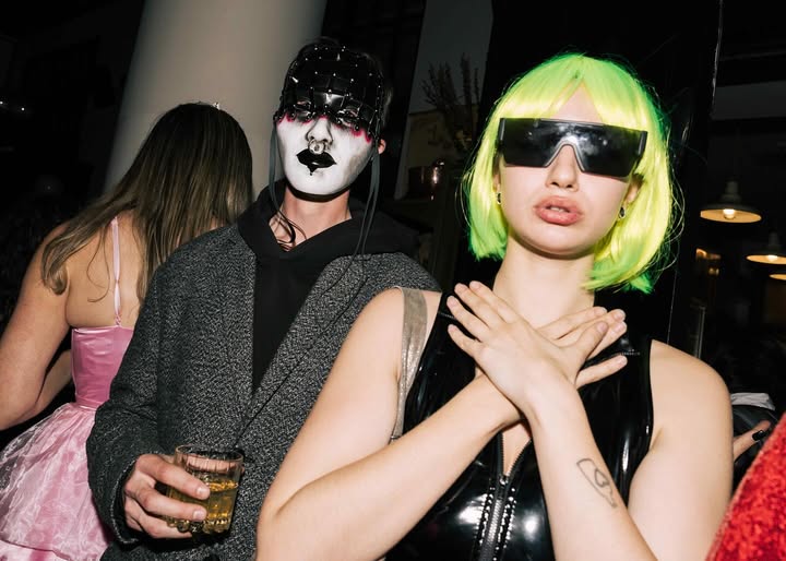 May be pop art of one or more people, makeup, fishnet stockings, eye patch, costume and glasses