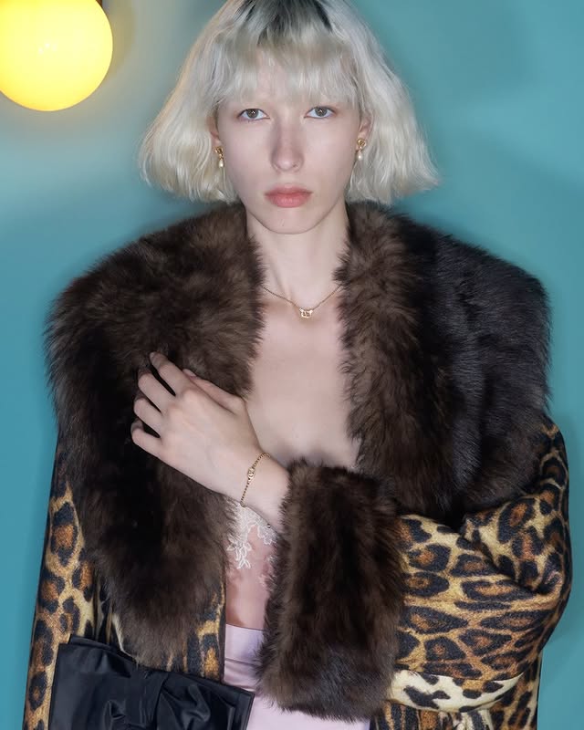 May be an image of one or more people, blonde hair, makeup, sable coat and text