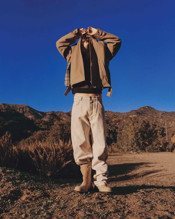 May be an image of standing, sweatpants, sweatsuit, turtleneck and text