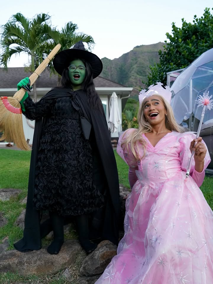 May be an image of one or more people, makeup, headdress, parasol, gown and costume